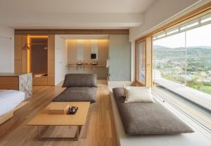 a bedroom with a bed and a large window at WE Hotel Toya - Dusit Collection in Lake Toya +51 photos