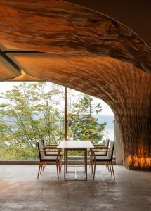 WE Hotel Toya في بحيرة تويا: طاولة وكراسي في غرفة مع نافذة كبيرة