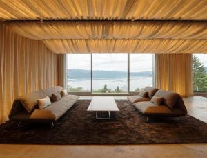 una sala de estar con 2 sofás y una ventana grande en WE Hotel Toya en Lake Toya