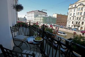 einen Balkon mit einem Tisch und einem Teller Bananen in der Unterkunft Pushka INN hotel in Sankt Petersburg