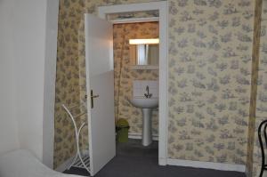 a bathroom with a sink and a mirror and a door at Château De La Croix Bizet in Moulineaux +36 photos