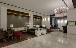 a lobby with a couch and chairs and a chandelier at The Elanza Hotel, Bangalore in Bengaluru