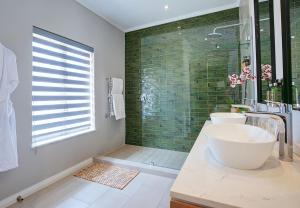 a bathroom with a tub, sink, and mirror at Knysna Hollow Country Estate in Knysna