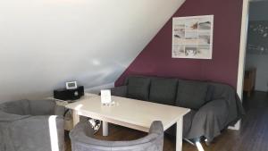 sala de estar con mesa y sofá en Elbe19 Ferienwohnung, en Marschacht
