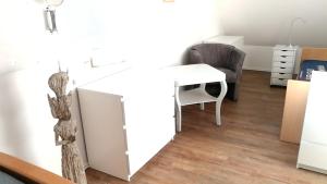Zimmer mit einem weißen Schreibtisch und einem Stuhl in der Unterkunft Elbe19 Ferienwohnung in Marschacht