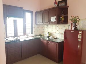 a kitchen with a red refrigerator and a sink at Palakal Residency in Cochin