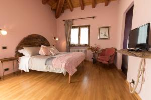 a bedroom with a bed and a flat screen tv at Le Jasmin in Aosta