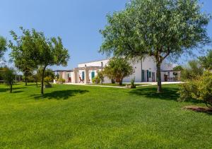 a white building with trees in a yard at Agriturismo Le Terre in Mesagne