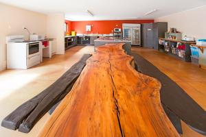 a large wooden table in the middle of a kitchen at Beachcomber Lodge & Backpacker in Kaitaia