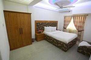 1 dormitorio con 1 cama, armario y ventana en Nagar Valley Hotel Ltd., en Dhaka