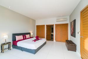 a bedroom with a bed with a red ribbon on it at Villa Marinella in Lamai +2 photos