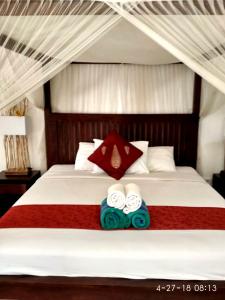 a bedroom with a bed with two towels on it at Jayastuti House in Ubud