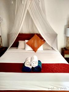 a bedroom with a bed with towels on it at Jayastuti House in Ubud
