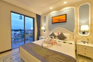 una camera da letto con un grande letto con una grande finestra di Hoi An Rosemary Boutique Hotel & Spa a Hoi An
