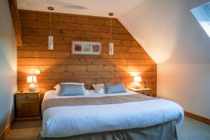 um quarto com uma cama grande e paredes de madeira em Hôtel Saint-Pierre em Pontarlier