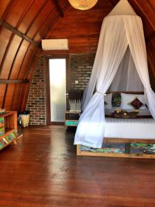 a bedroom with a bed with a mosquito net at Balangan Sea View Bungalow in Jimbaran