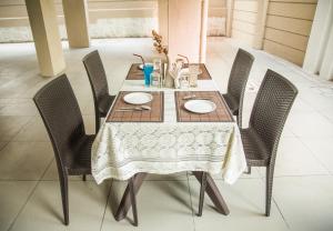 a dining room table with chairs and a white table cloth at Hotel Nirvana in Alibaug