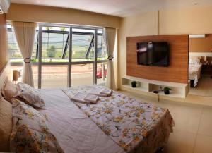 1 dormitorio con 1 cama y TV en la pared en Flat Tambaú Solar do Atlântico, en João Pessoa