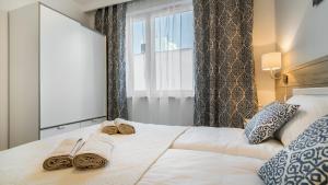 グダニスクにあるhvile 104 - Gdańsk TRE MAREのベッドルーム1室(タオル付きのベッド1台、窓付)