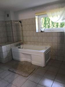 a white bath tub in a bathroom with a window at Przytulne mieszkanie w urokliwej okolicy in Chodzież