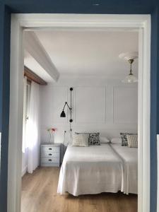 Habitación blanca con cama y ventana en Las Palomas en Porto de Espasante