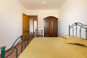 ウッジャーノ・ラ・キエーザにあるCasa Frulli by BarbarHouseのベッドルーム1室(ベッド1台付)、木製のドア