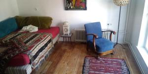 een slaapkamer met een bed en een blauwe stoel bij Het Goede Leven in Harlingen