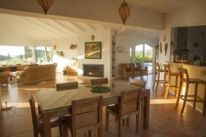 comedor y sala de estar con mesa y sillas en CASA JUANA grande luxueuse maison avec magnifique vue sur mer, en Cadaqués
