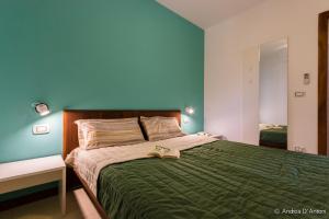 a bedroom with a bed with a green comforter at Apartamento Las Rochas in Mindelo