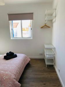 een slaapkamer met een bed en een raam bij Sea & Beach Apartment in Costa da Caparica