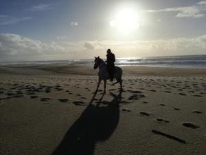una persona montando un caballo en la playa en Casa da Paraventa, en Gaieiras