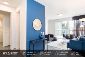 a living room with a blue accent wall at Modern 2BR Apt w Private Parking in City Center by Sea N' Rent in Ramat Hash Sharon