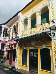 a yellow and white building on a street at Phuket Sunny Hostel in Phuket Town