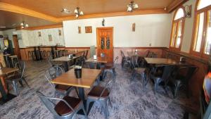 an empty restaurant with wooden tables and chairs at Hostal Rural El Padul in Padul