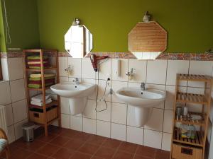 La salle de bains est pourvue de 2 lavabos et d'un mur vert. dans l'établissement Ferienwohnung Erkelenz, à Erkelenz