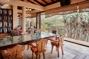 a dining room with a large glass table and chairs at AmmaZulu African Palace in Kloof
