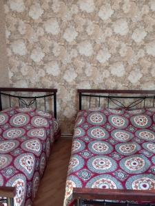two beds sitting next to each other in a bedroom at Guest House Medea in Tʼelavi