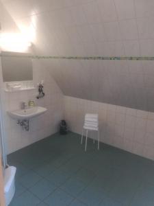 ein Badezimmer mit einem Waschbecken und einem Stuhl darin in der Unterkunft Hotel Altes Salzamt in Bad Dürrenberg