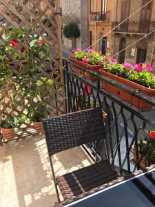 a bench sitting on a balcony with flowers at Verdi Apartment in Castellammare del Golfo