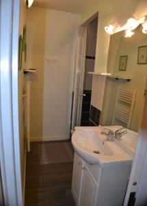 un baño con lavabo y espejo en "Le 5" RÉSIDENCE BROUSSE, en Le Mont-Dore