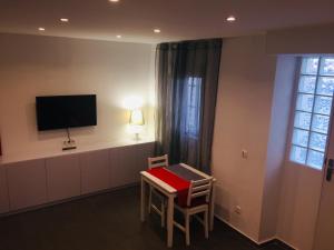 a room with a table and a tv on the wall at Apartamento Plaza De Toros Centro in Alicante