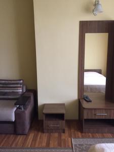 a bedroom with a bed and a mirror and a couch at DOLCHE VITA in Berkhomet-pe-Siret