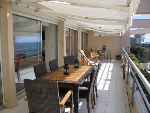 a table and chairs on the balcony of a house at Luxury apartment facing the Mediterranean in Sète