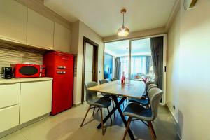 a kitchen with a table and chairs and a red refrigerator at Apartment Chic by Landev in Braşov