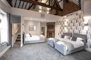two beds in a large room with white walls at The Glebe Hotel in Liverpool