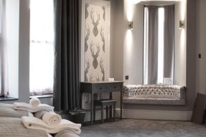 a bedroom with a bed and a table with towels at The Glebe Hotel in Liverpool