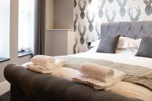 a bedroom with a bed with two towels on it at The Glebe Hotel in Liverpool