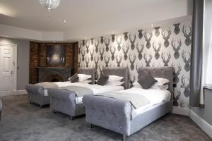 a bedroom with two beds and a fireplace at The Glebe Hotel in Liverpool
