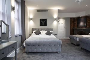 a bedroom with a bed and a couch and a fireplace at The Glebe Hotel in Liverpool