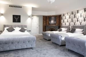 a bedroom with two beds and a fireplace at The Glebe Hotel in Liverpool